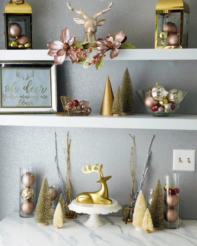 Blush pink and gold holiday decor. Christmas bulbs decorating, lanterns and bottle brush trees.