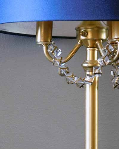 navy blue lamp shade on gold lamp with beaded jewelry