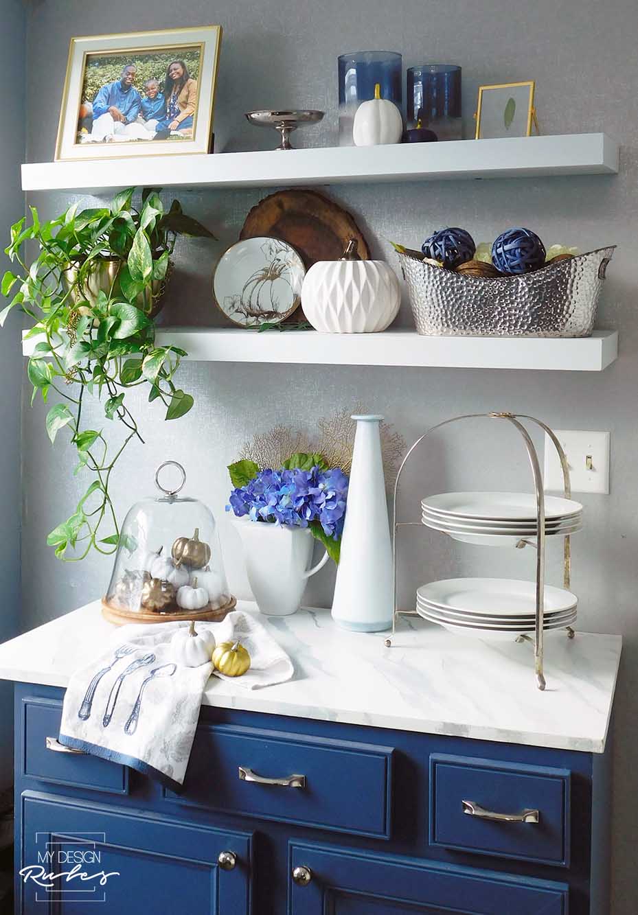 blue buffet  and floating shelves decorated for fall